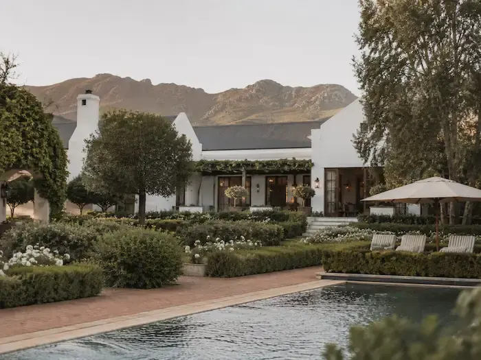 A restored Cape Dutch manor house with a garden and pool